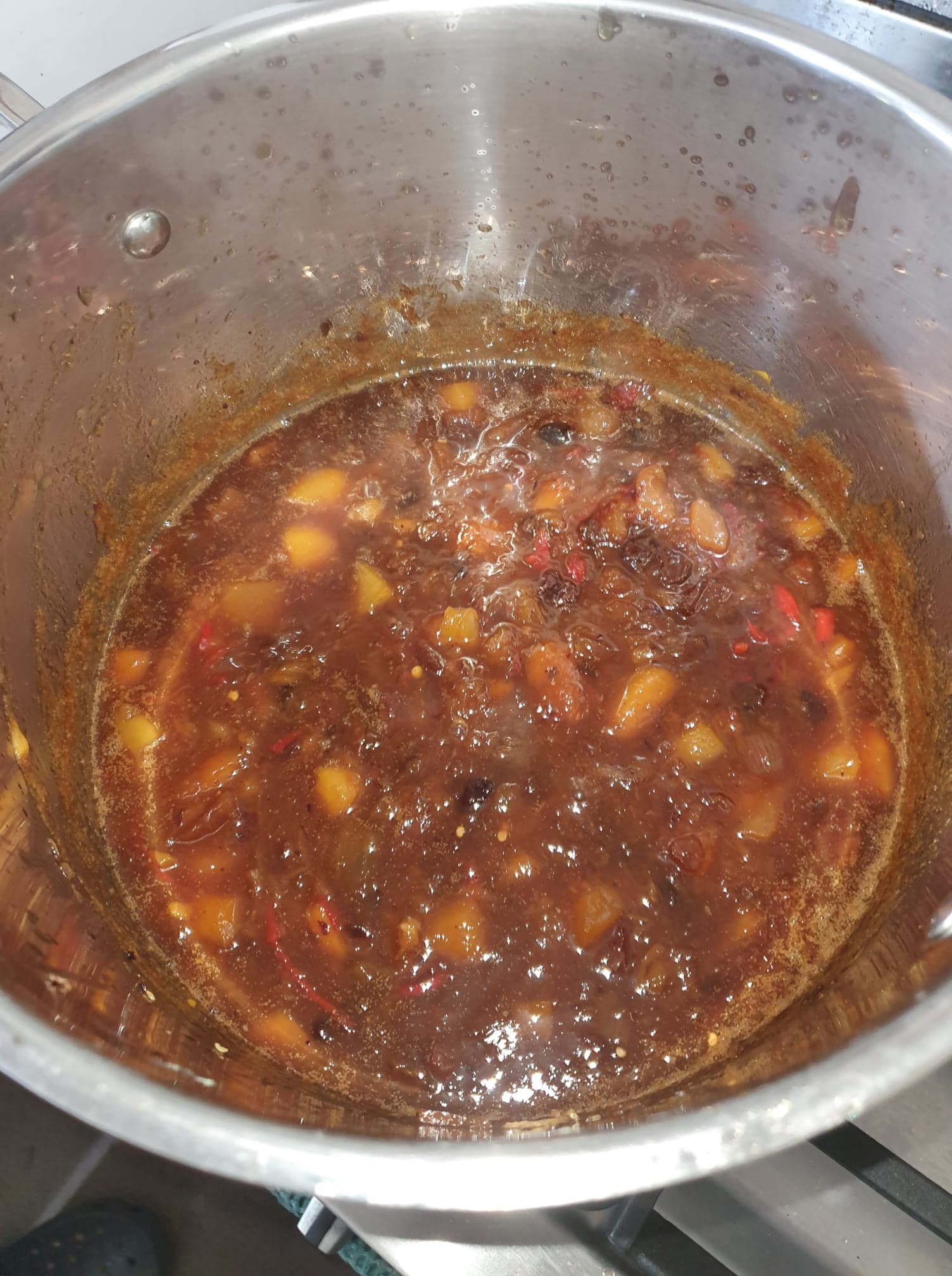 A jar of Rhonda's Spicy Mango Chutney with chilli slices visible inside